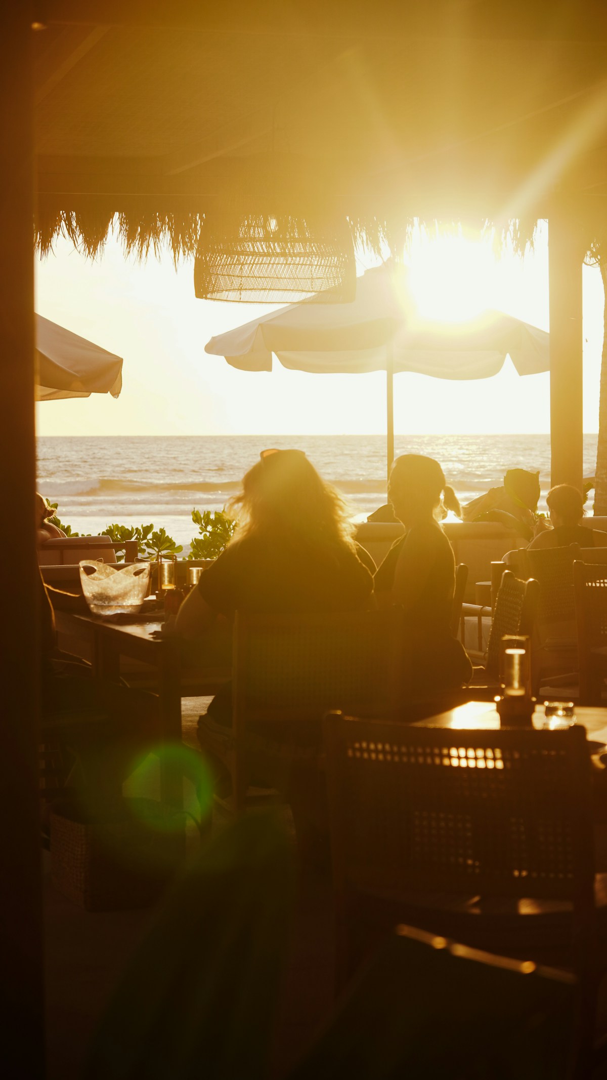 People dining at a beachside restaurant at sunset, eastern Sri Lanka coast