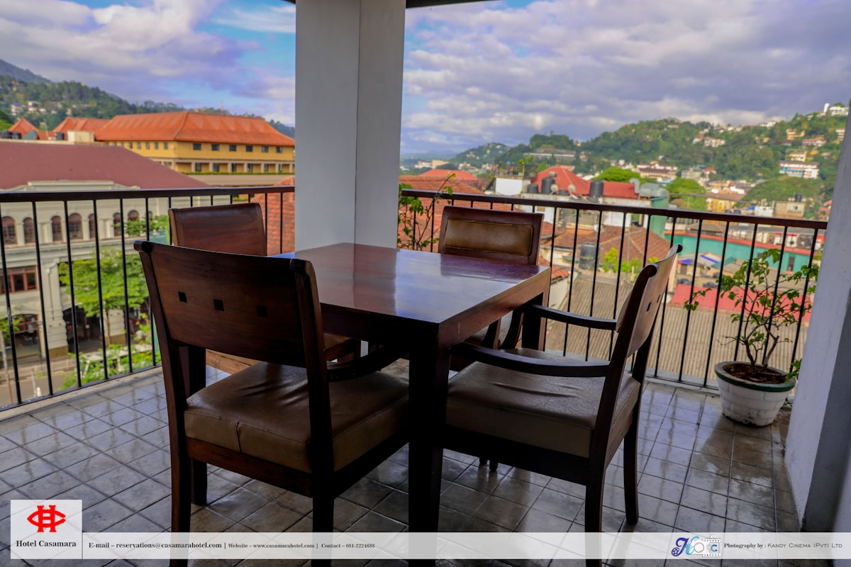 Hotel balcony dining table with view over Kandy city rooftops and hills, Sri Lanka
