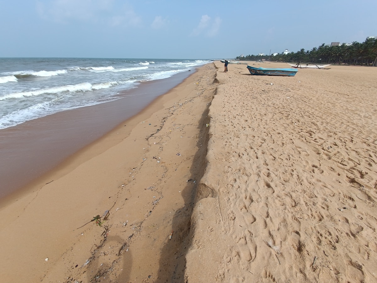 Wide sandy beach with fishing boat at Ettukala, Negombo, Sri Lanka
