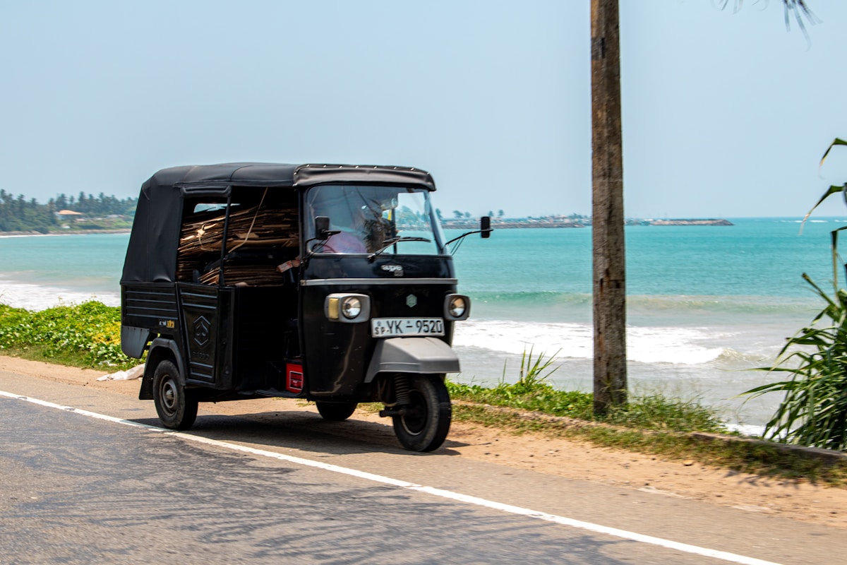 Black tuk-tuk beside the ocean — day trip from Colombo, Sri Lanka
