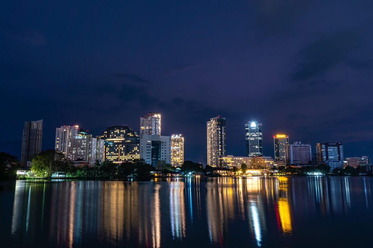 Colombo skyline reflected in water at dusk, with the Lotus Tower visible
