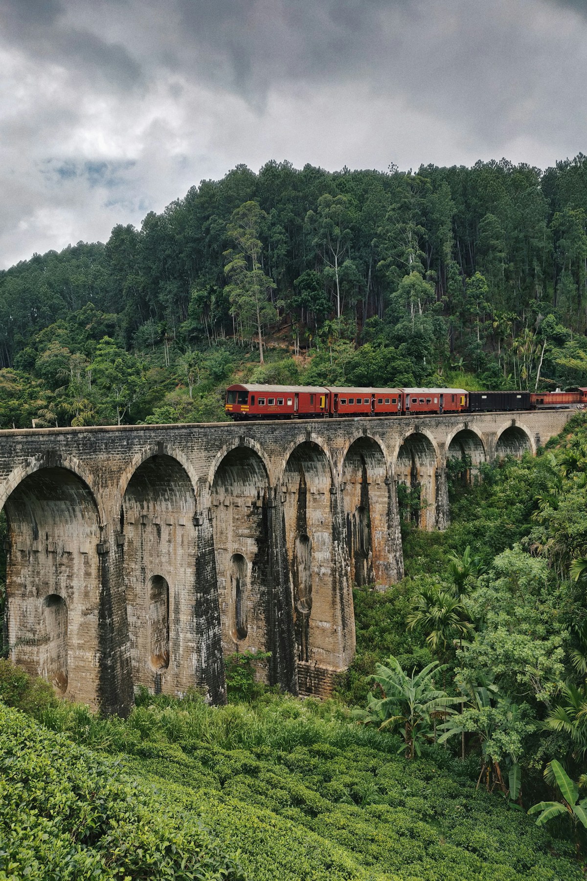 Train crossing the Nine Arches Bridge through forest, Ella, Sri Lanka