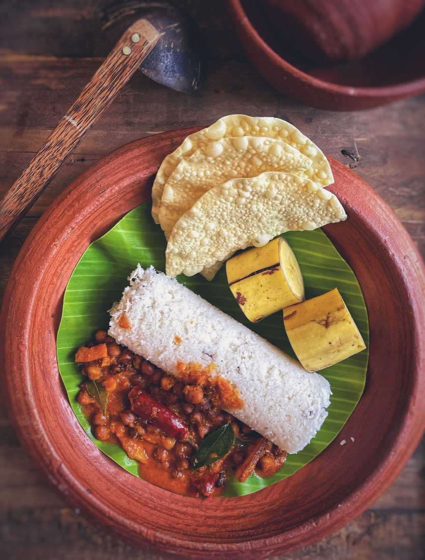 Puttu with chickpea curry and papadums on a banana leaf, Sri Lanka