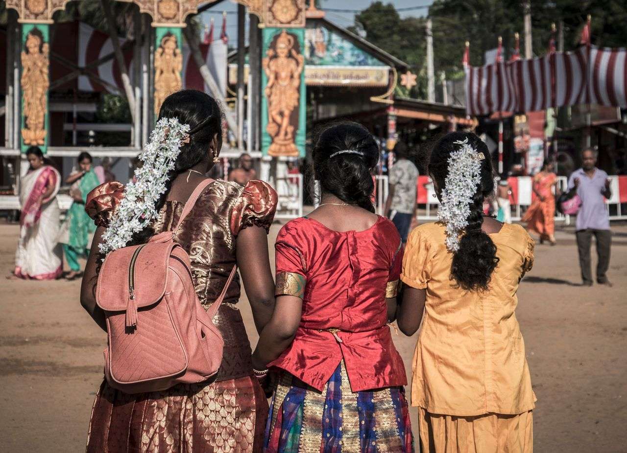 Tamil women in traditional silk sarees walking toward a Hindu temple festival ground, Jaffna, northern Sri Lanka