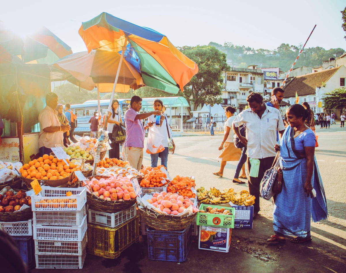 Street market with fresh fruit stalls and shoppers, Kandy, Sri Lanka