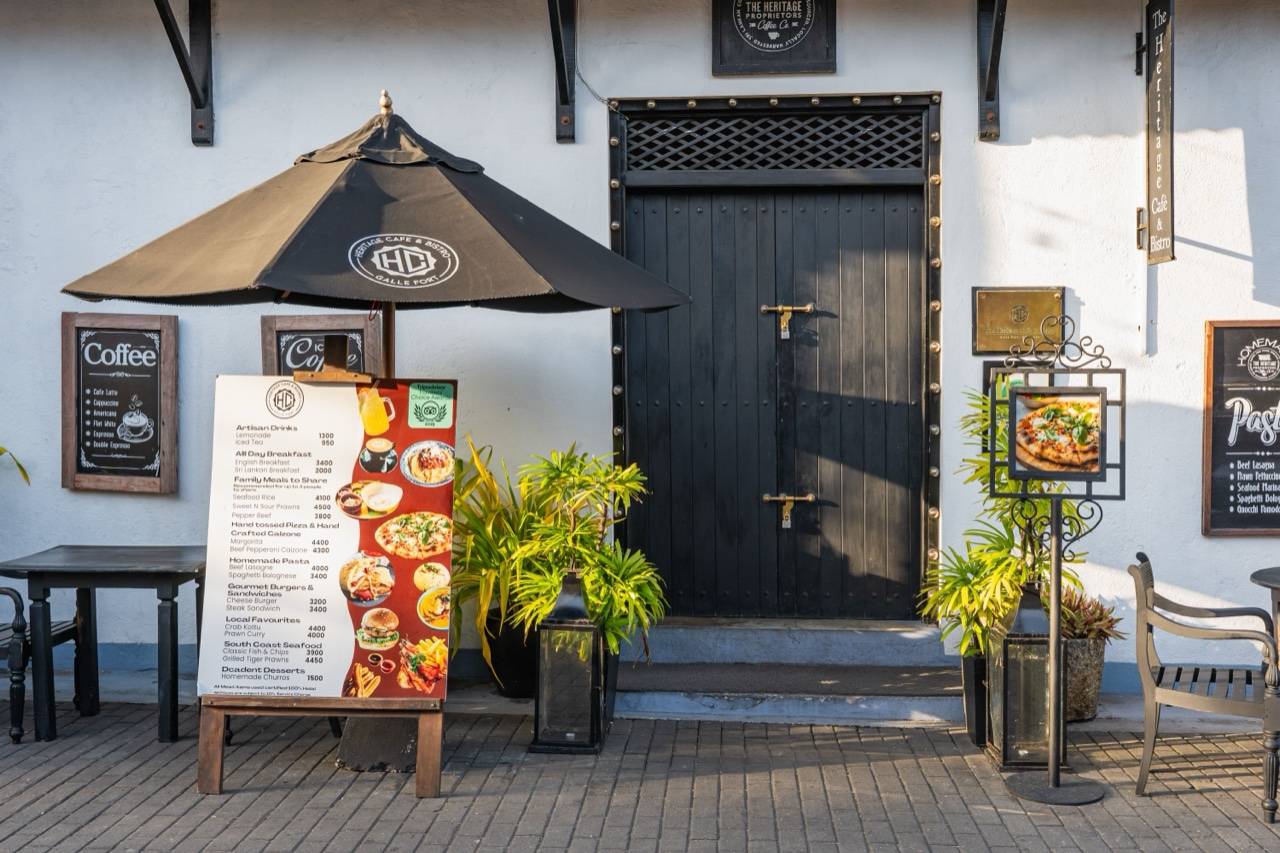 Cafe entrance with menu board and outdoor seating, Mirissa, Sri Lanka