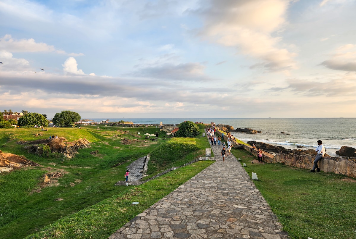 Path leading toward the ocean under a cloudy sky, southern Sri Lanka