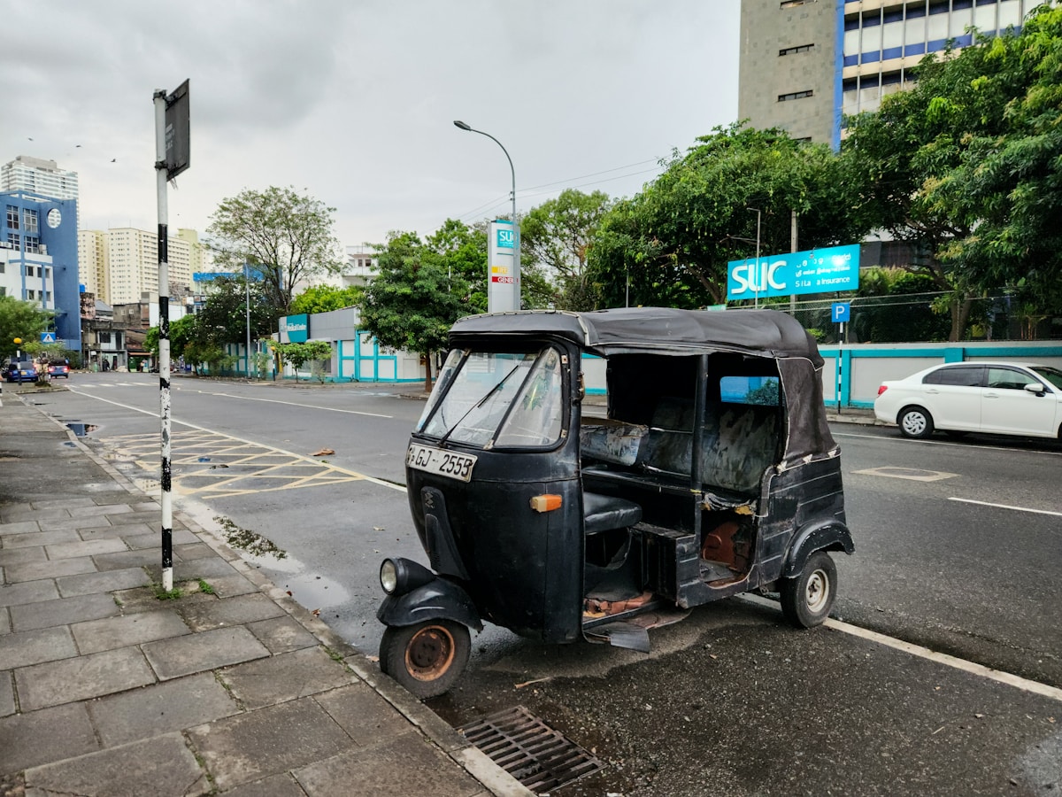 Black tuk-tuk parked on a city street in Colombo, Sri Lanka