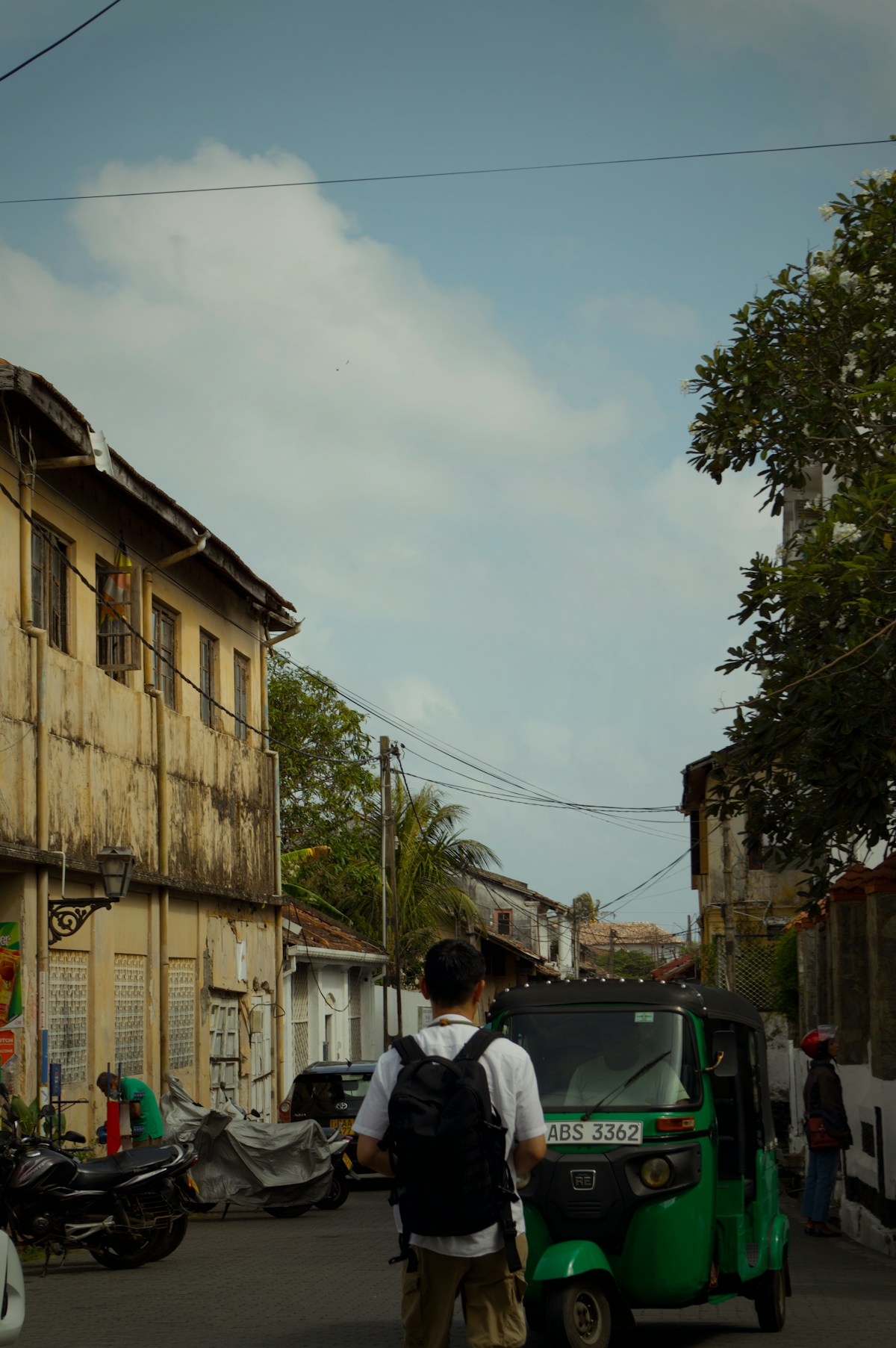 Traveller walking past a tuk-tuk on a Sri Lanka street