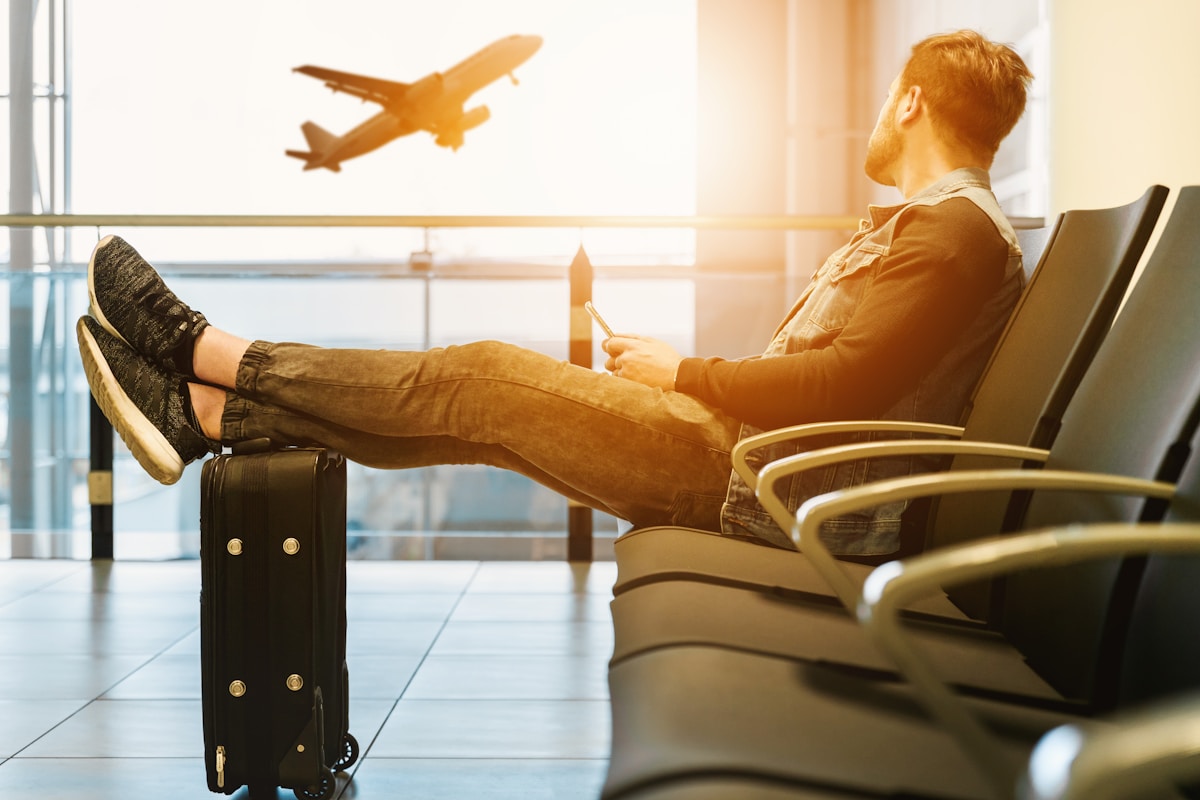 Traveller sitting with luggage at an airport terminal